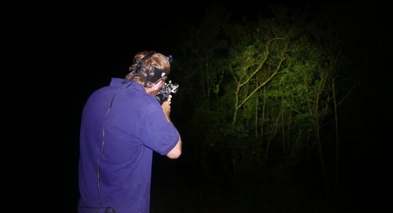 Wildlife biologist Adam Knox demonstrating the use of an airsoft gun to stun invasive brown tree snakes.